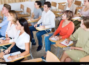 un estudiante emocionado escuchando atentamente a un profesor en un aula