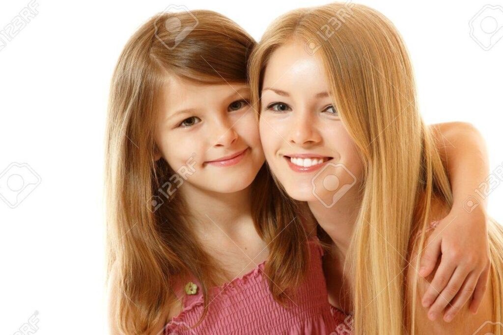 una foto de dos hermanas abrazandose sonrientes