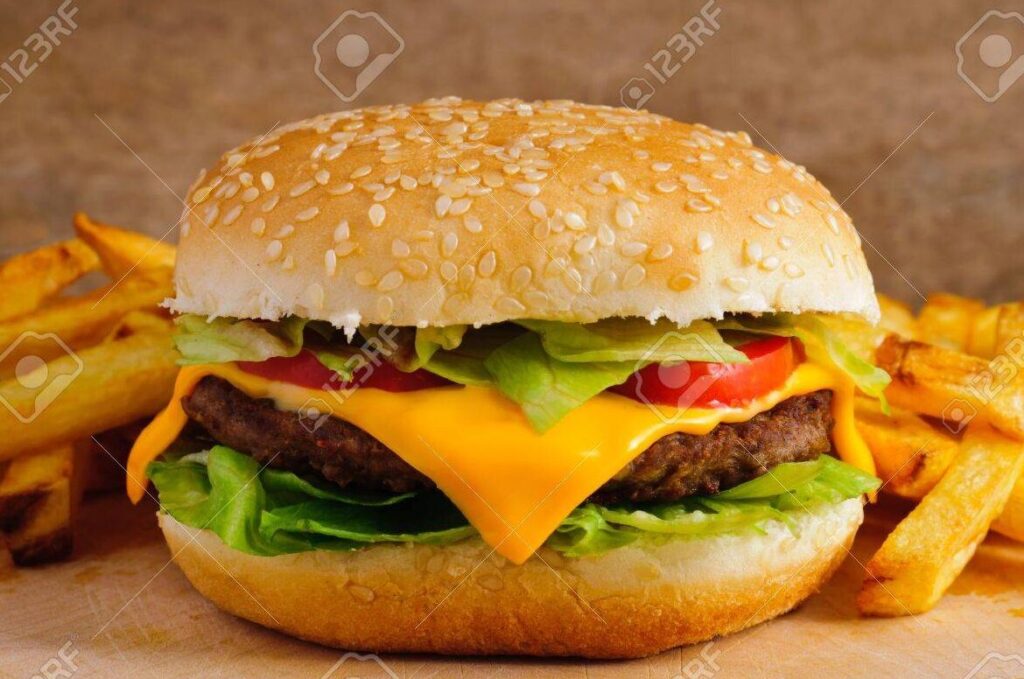 una foto de una deliciosa hamburguesa con queso y papas fritas en un plato