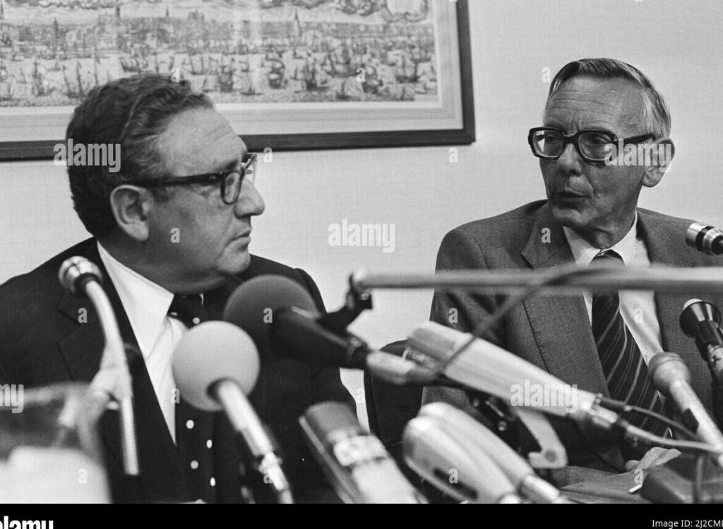 una foto en blanco y negro de henry kissinger en una conferencia de prensa