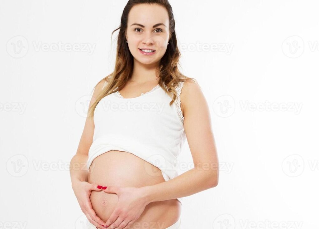 una imagen con una mujer embarazada sonriendo y tocando su vientre