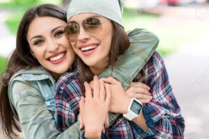 una imagen de dos hermanas sonriendo mientras se abrazan