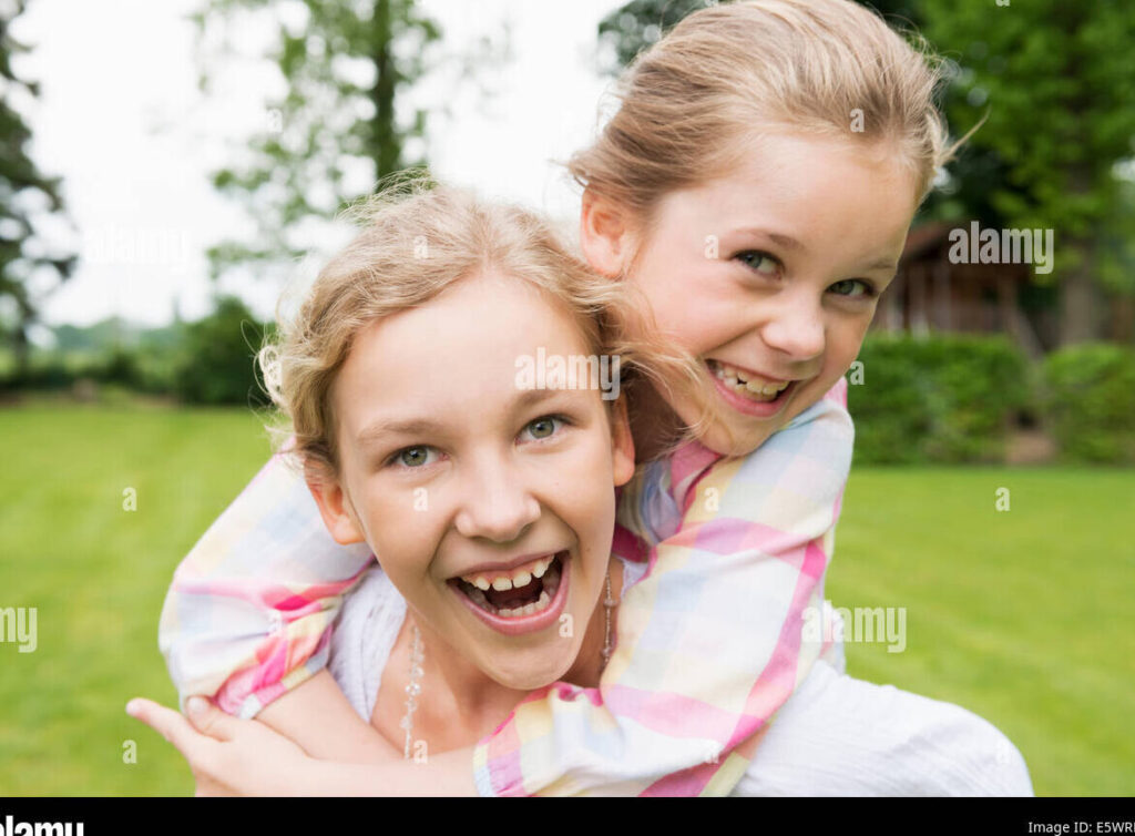 una imagen de dos hermanas sonrientes abrazandose afectuosamente