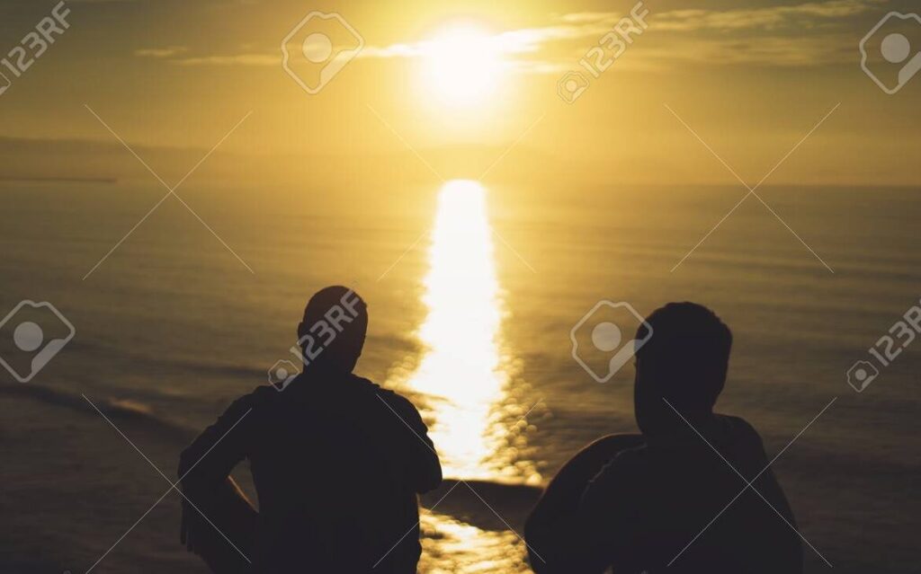 una imagen de dos personas sonrientes abrazandose al amanecer