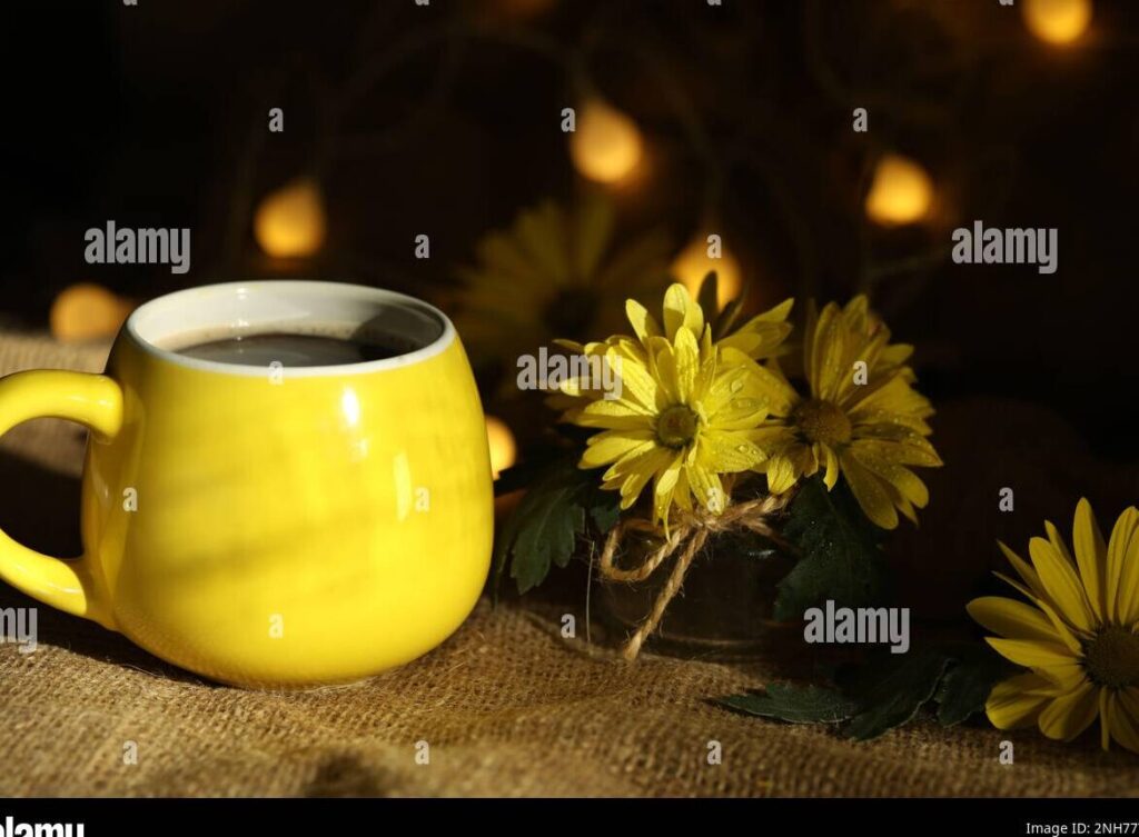 una imagen de un amanecer con colores vibrantes y una taza de cafe humeante en primer plano