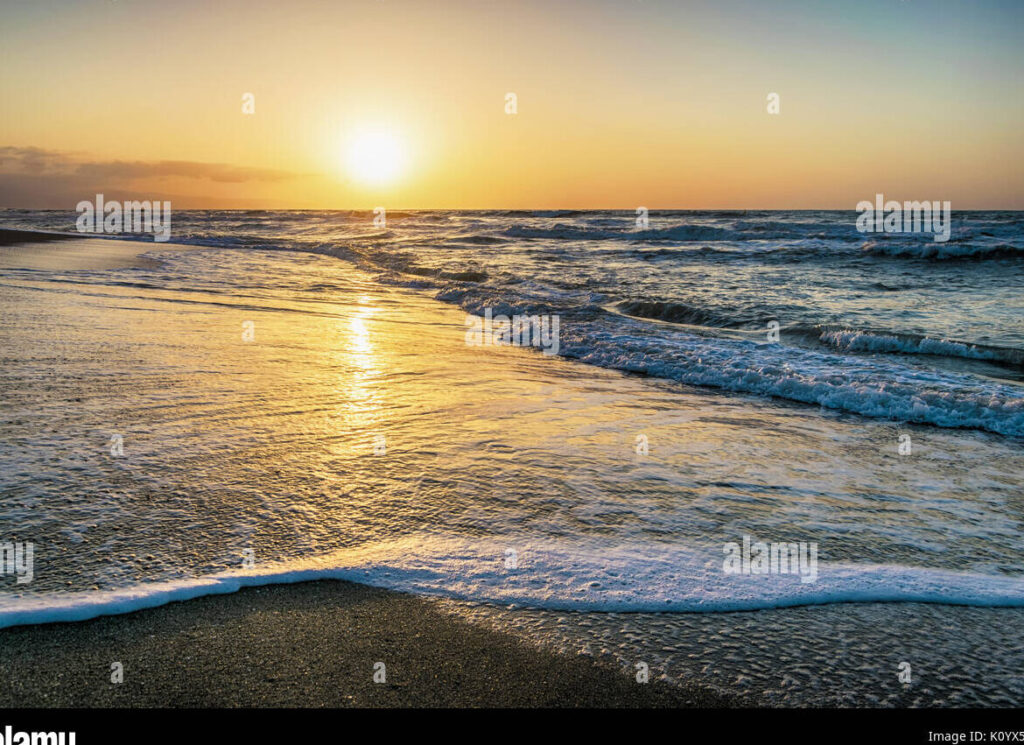una imagen de un amanecer en la playa con colores calidos y tranquilos