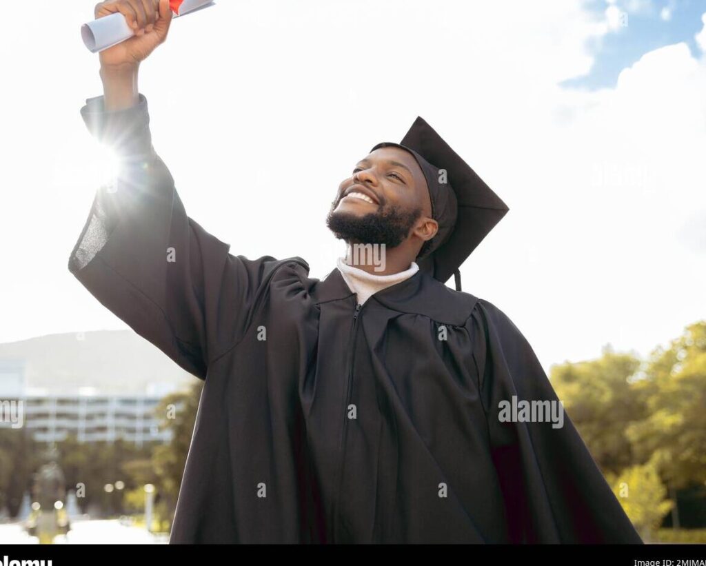 una imagen de un joven graduado con toga y birrete sosteniendo un microfono y mirando al publico con una sonrisa emocionada