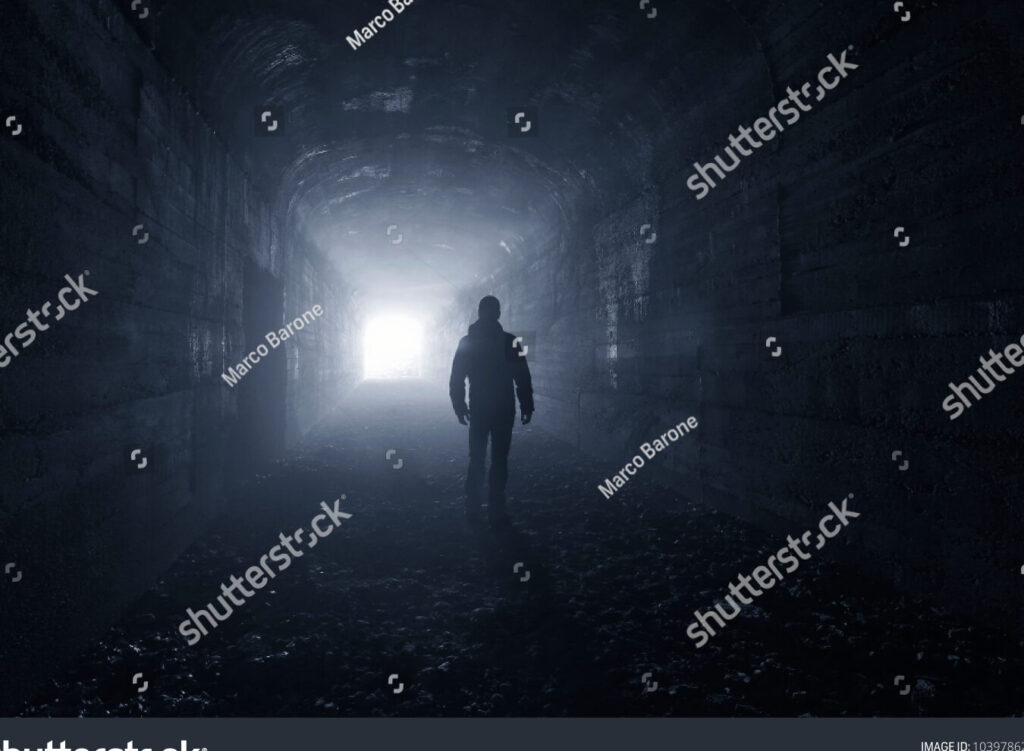 una imagen de un laberinto oscuro con un corredor solitario en el centro