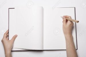 una imagen de un libro abierto con paginas en blanco y una mano sosteniendo un lapiz