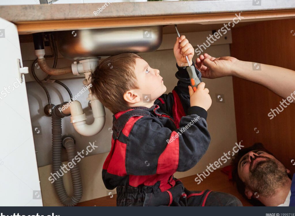 una imagen de un nino imitando a su padre en una actividad adulta como por ejemplo vestido con ropa de trabajo y usando herramientas de trabajo similares a las de su padre