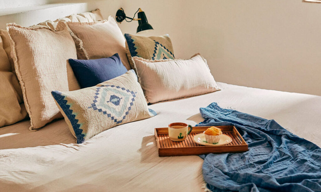 una imagen de una cama con sabanas suaves y decoraciones relajantes