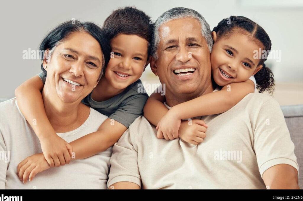 una imagen de una familia feliz con abuelos sonrientes rodeados de sus nietos