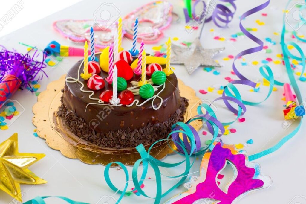 una imagen de una fiesta de cumpleanos con globos confeti y una tarta de cumpleanos decorada