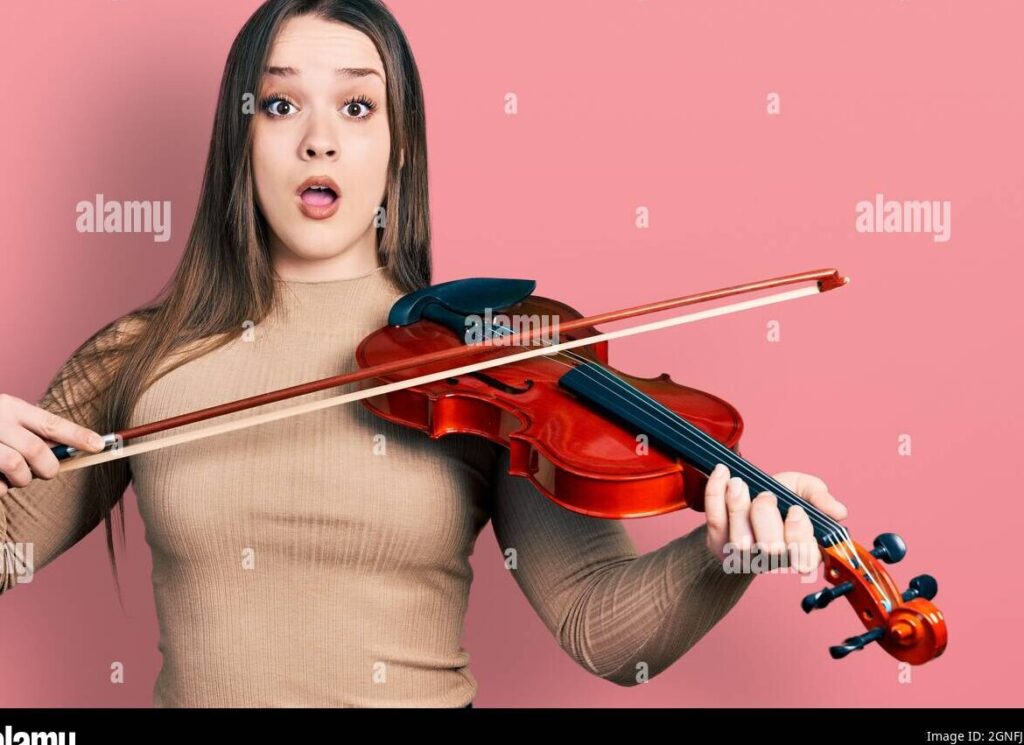 una imagen de una joven sosteniendo un violonchelo con expresion de sorpresa y emocion