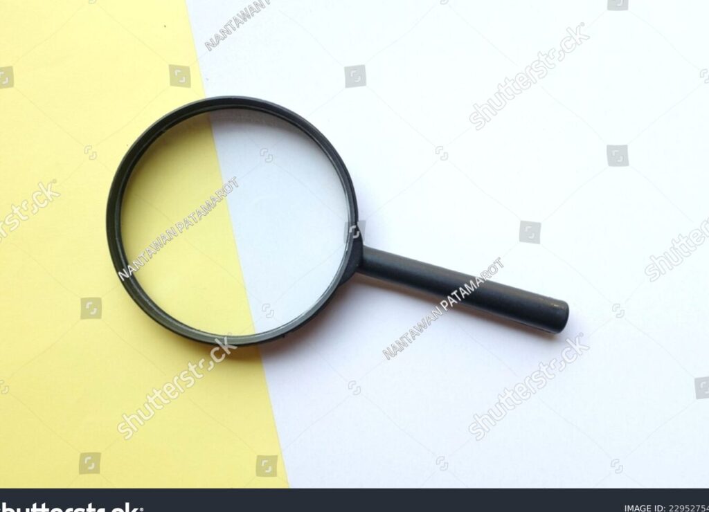 una imagen de una lupa enfocando un pequeno detalle en medio de un fondo borroso