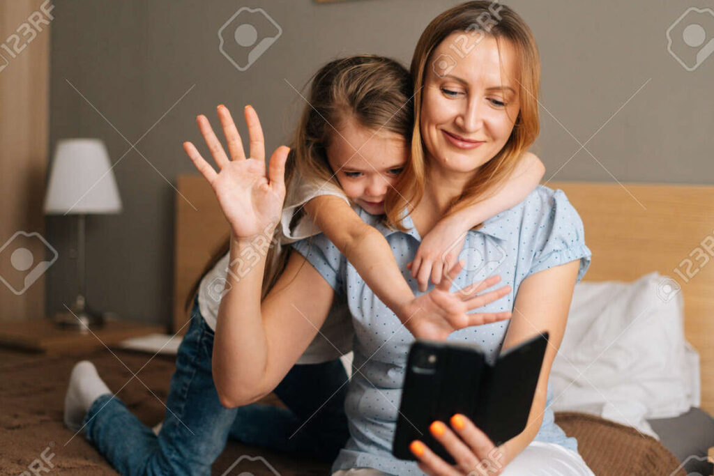 una imagen de una madre y una hija abrazandose a traves de una videollamada