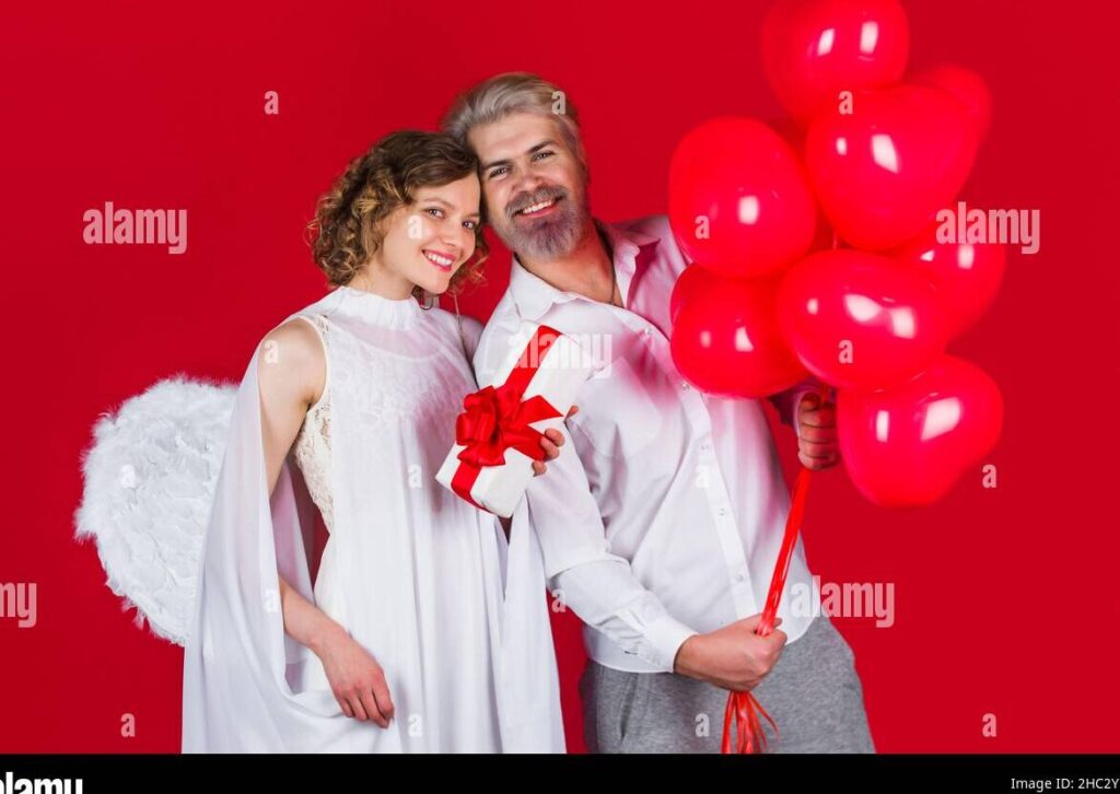 una imagen de una pareja mayor sonriendo y celebrando juntos rodeados de globos y confeti