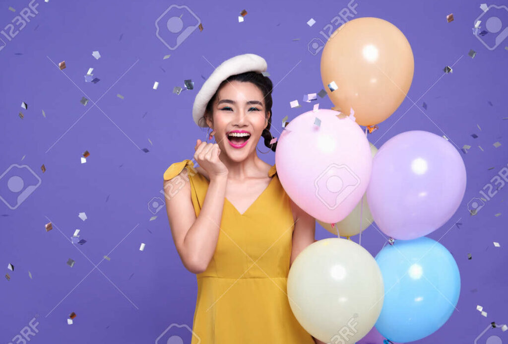 una imagen de una persona sonriendo rodeada de globos y confeti