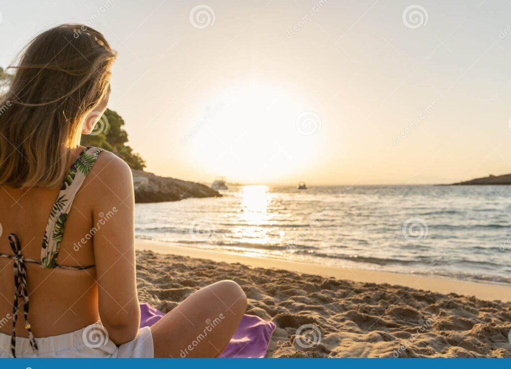 una imagen de una persona sonriente disfrutando de un hermoso amanecer en la playa