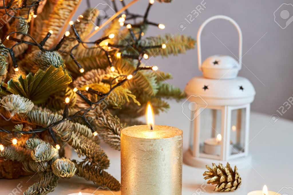 una imagen de una vela encendida con una decoracion navidena de fondo