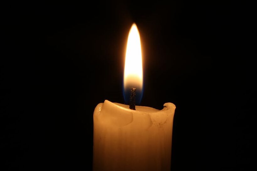 una imagen de una vela encendida en un lugar oscuro