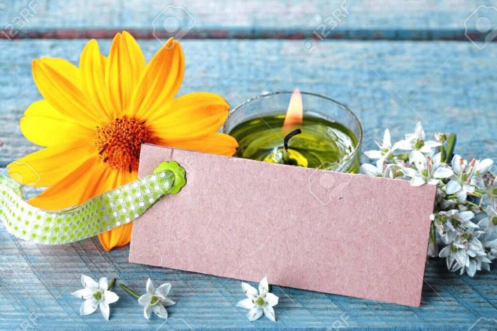una imagen de una vela encendida rodeada de petalos de flores y una tarjeta con la palabra gracias escrita en ella