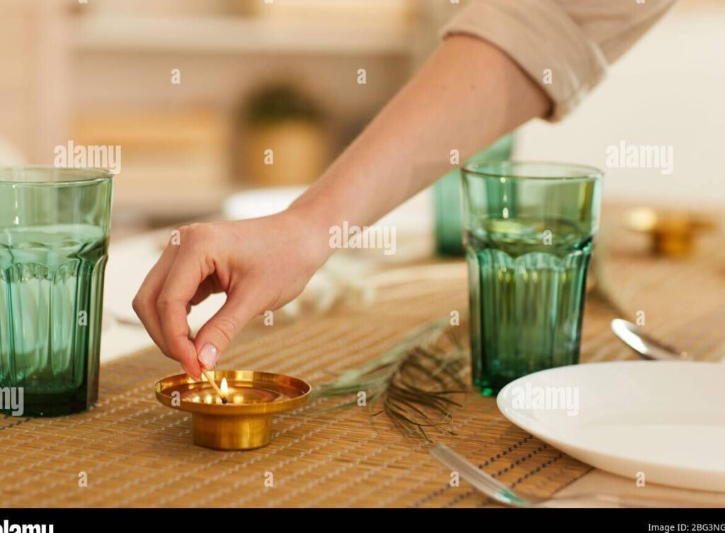 una imagen de una vela encendida y una fotografia enmarcada de una madre sonriente