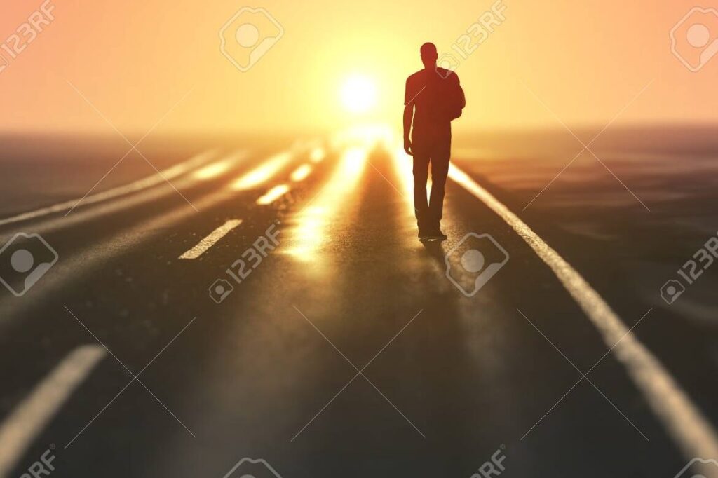 una imagen que muestre una persona caminando por un camino recto y claro hacia un horizonte brillante