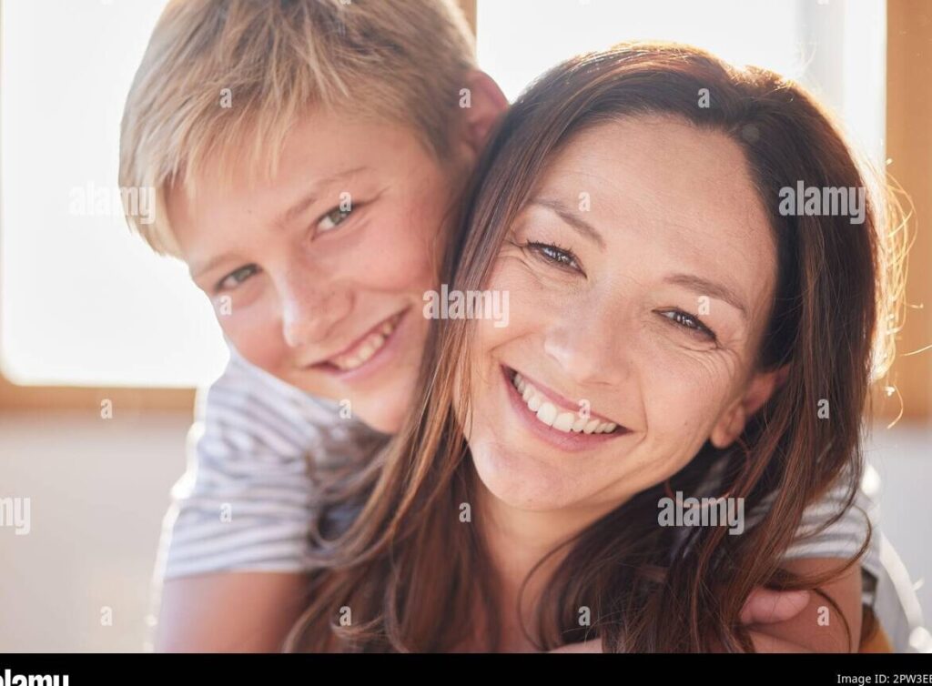 una madre abrazando a su hijo con una sonrisa calida en su rostro