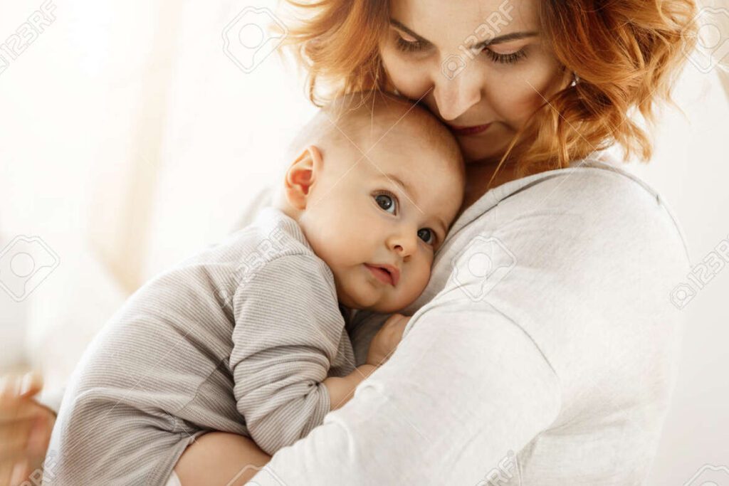 una madre sonriente abrazando tiernamente a su hijo