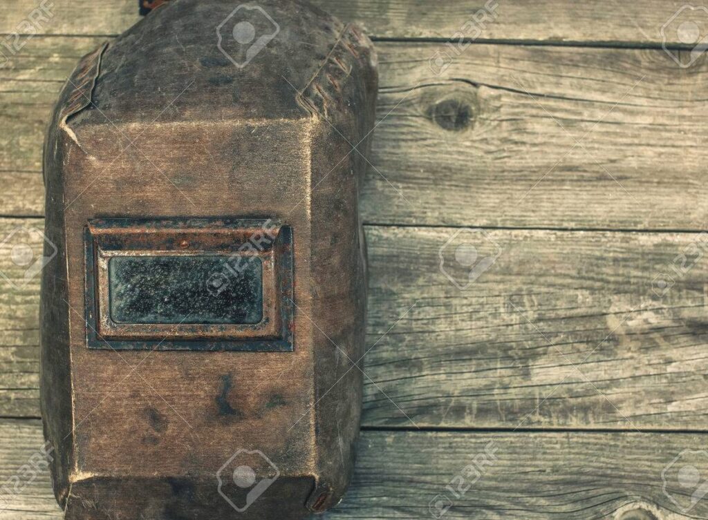 una mascara de hierro en una antigua mesa de madera