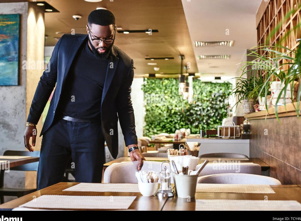 una mesa elegante con platos y cubiertos rodeada de personas en trajes de negocios sonriendo y disfrutando de la comida