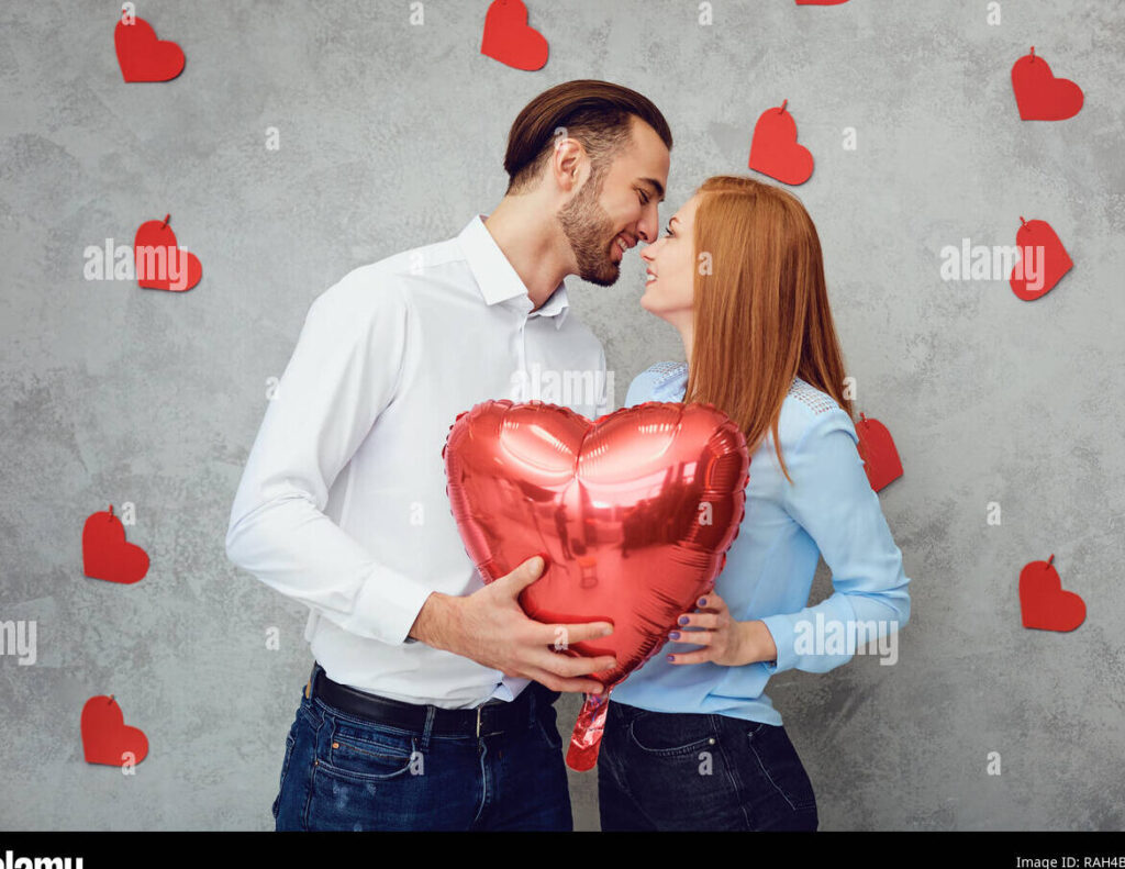 una pareja feliz sosteniendo un globo con el numero 5 en un fondo romantico
