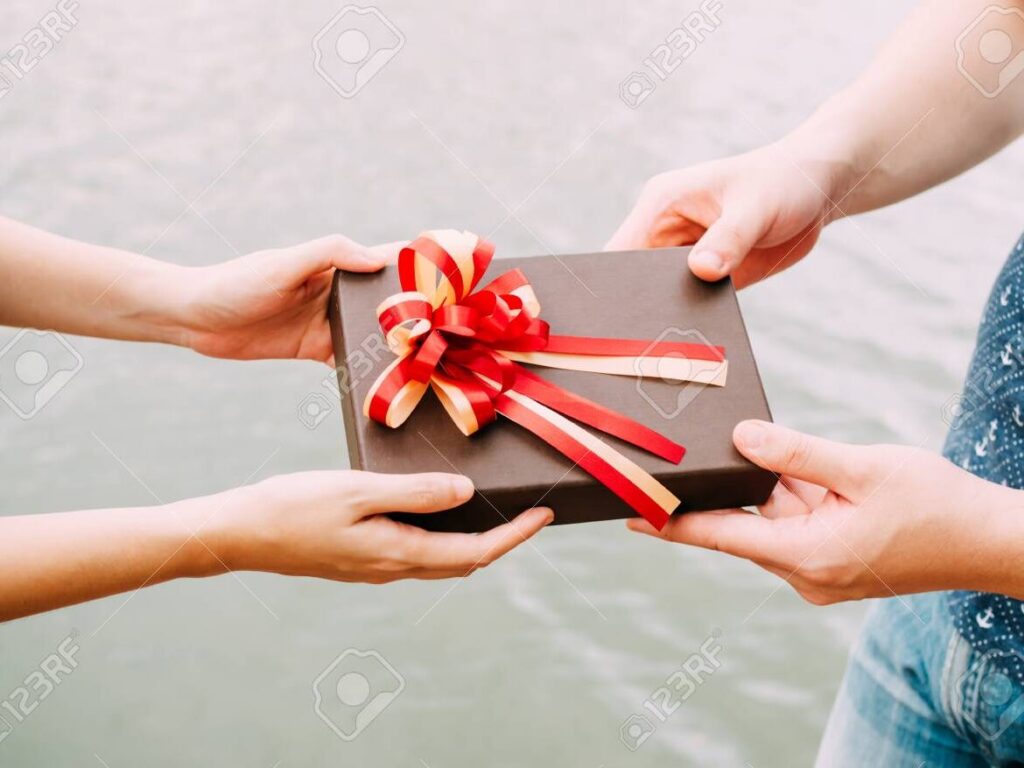 una pareja feliz sosteniendo un regalo envuelto con un lazo rojo