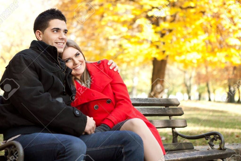 una pareja sonriente abrazandose en un parque 1