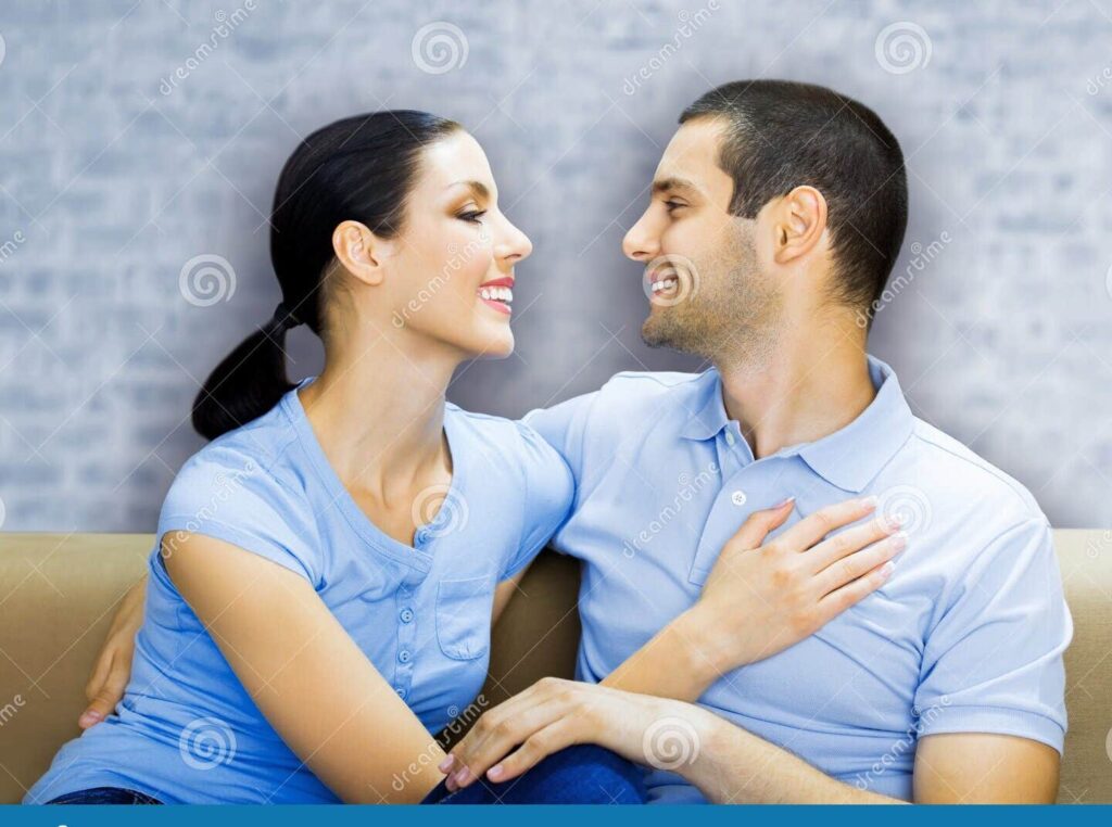 una pareja sonriente abrazandose y mirandose amorosamente
