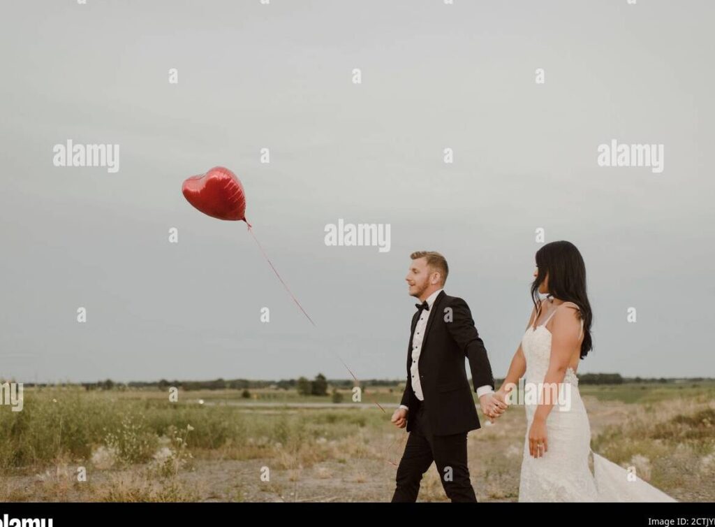 una pareja sosteniendo globos en forma de corazon mientras se alejan
