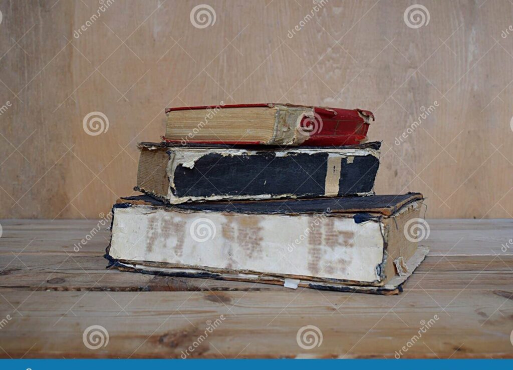 una pila de libros antiguos en una estanteria de madera