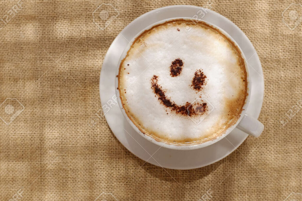 una taza de cafe con una sonrisa dibujada en la espuma 5